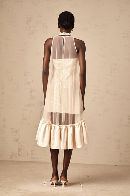 A glamorous midi dress with a layered skirt featuring sequin embellishments and sheer tulle panels adding elegance and texture to the design
