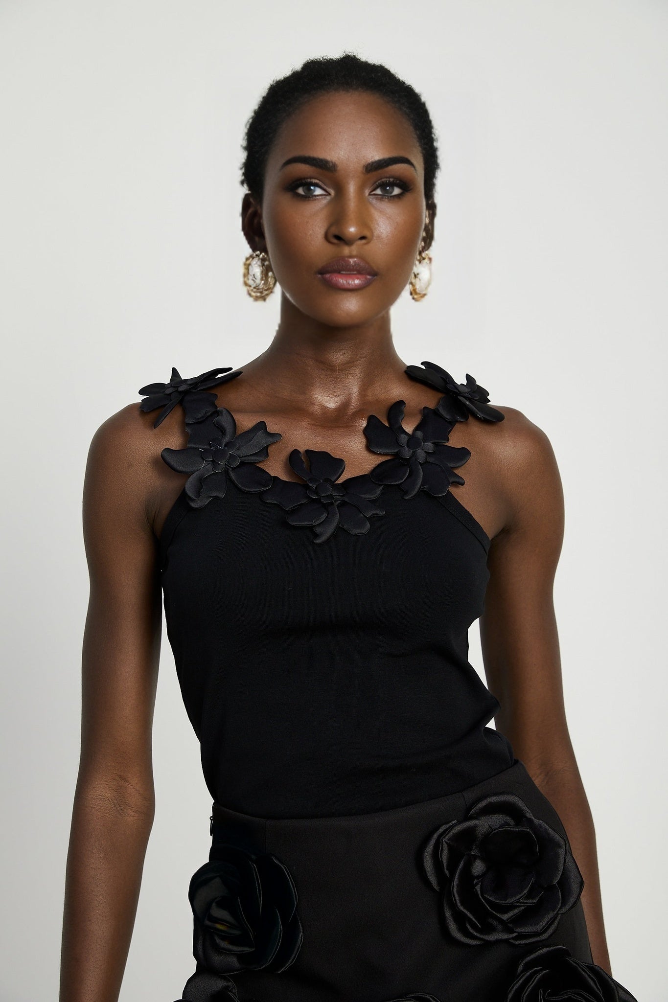 Black mini skirt with artificial flowers by Nalini