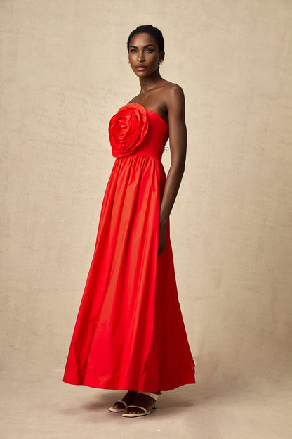 A long red maxi dress with ruffled 3d petal details covering the entire garment creating a textured floral effect