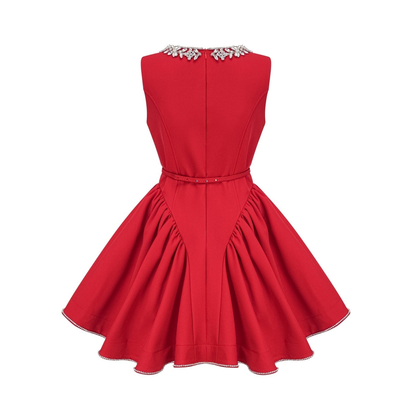 Young woman wearing a red pleated mini dress with embellishments standing in front of a plain background