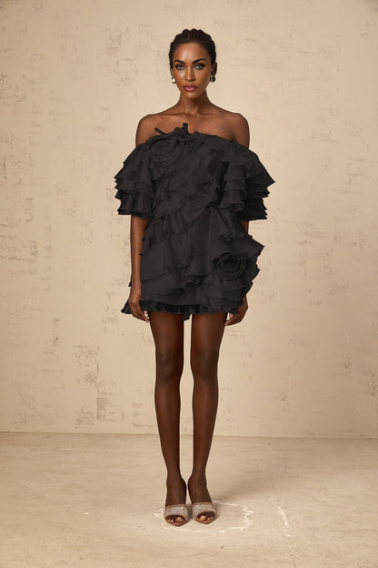 Black mini dress with asymmetric design featuring cerise flounce detail