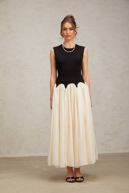 A long flowing maxi dress with puffed sleeves featuring colorblocked sections in contrasting hues named Josette