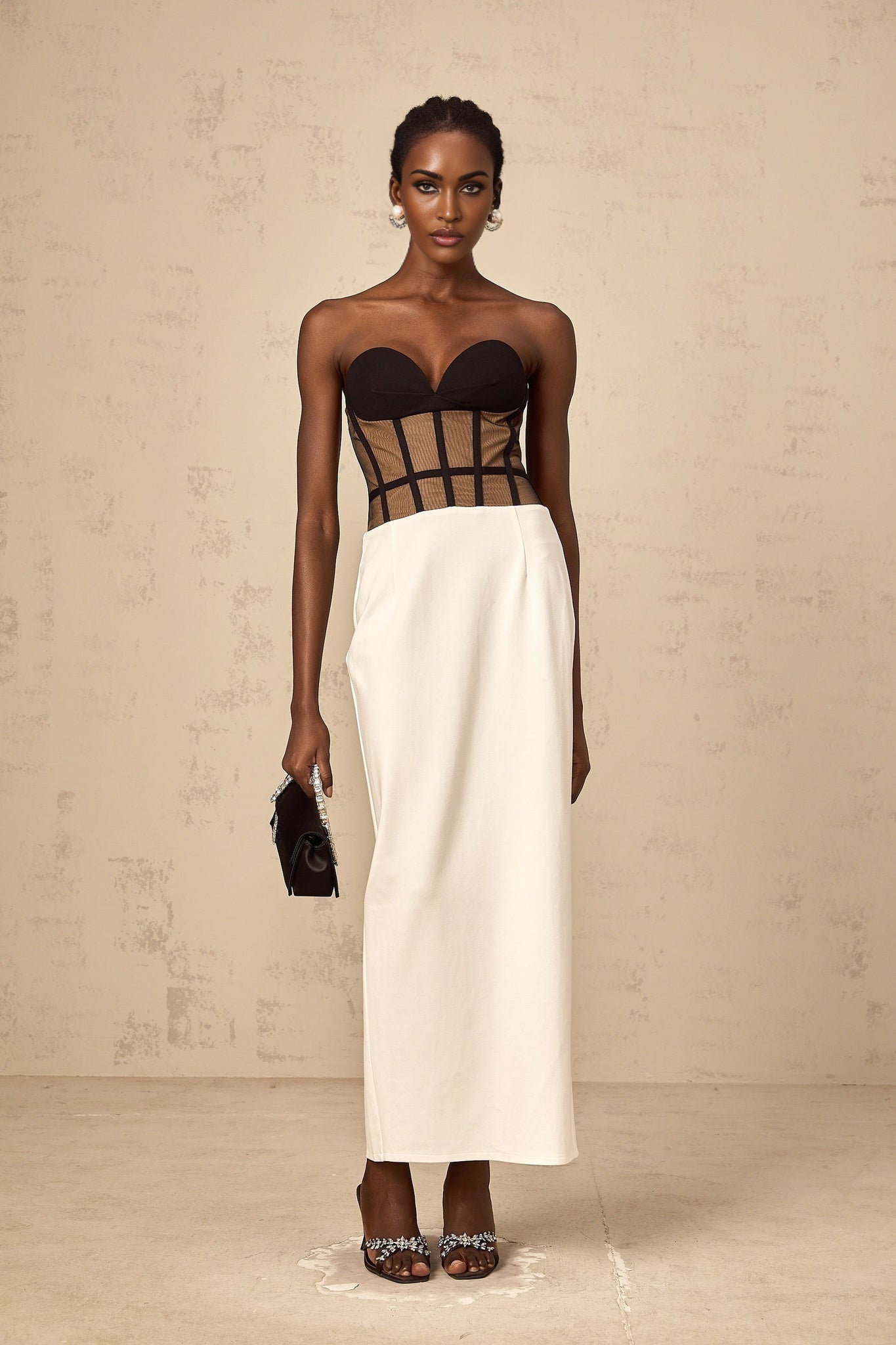 A long sheer maxi dress with a corset bodice featuring contrasting colors and a flowing skirt