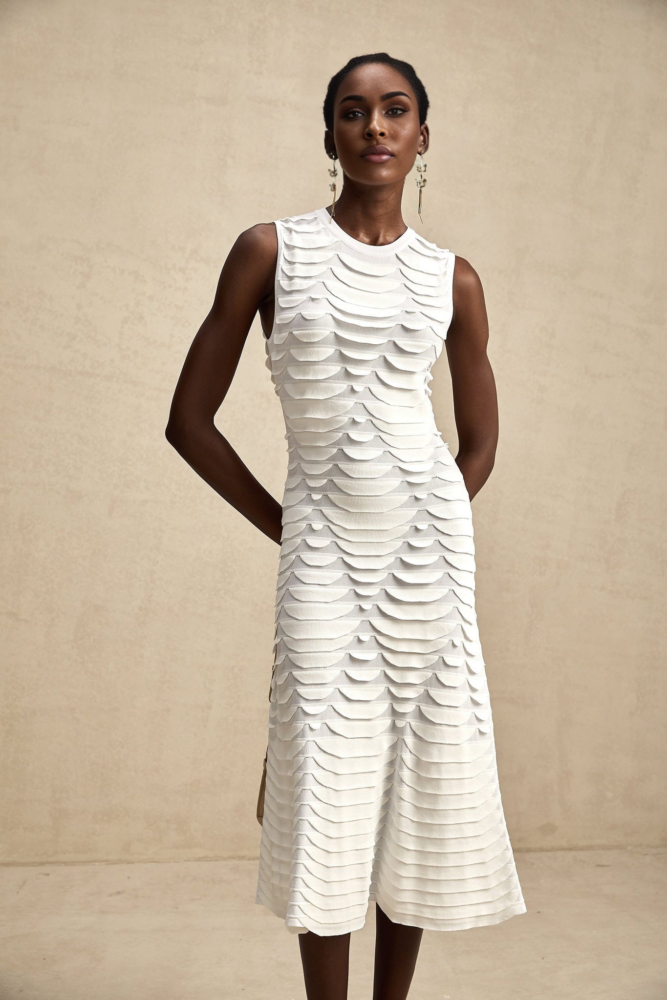 Woman wearing long black and white snake pattern dress with flared skirt reaching mid calf