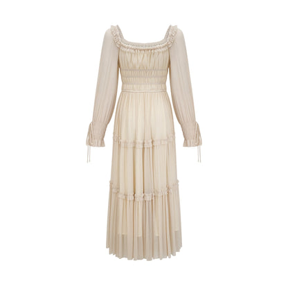 Woman wearing a metallic pleated midi dress with shirred details and a flowy silhouette