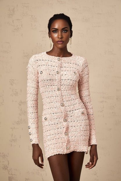 A pink fitted knit mini dress on a mannequin or model showcasing its formfitting silhouette and short length