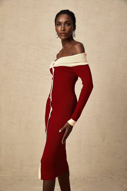 Woman wearing a beige offshoulder knit midi dress with long sleeves standing against a plain background