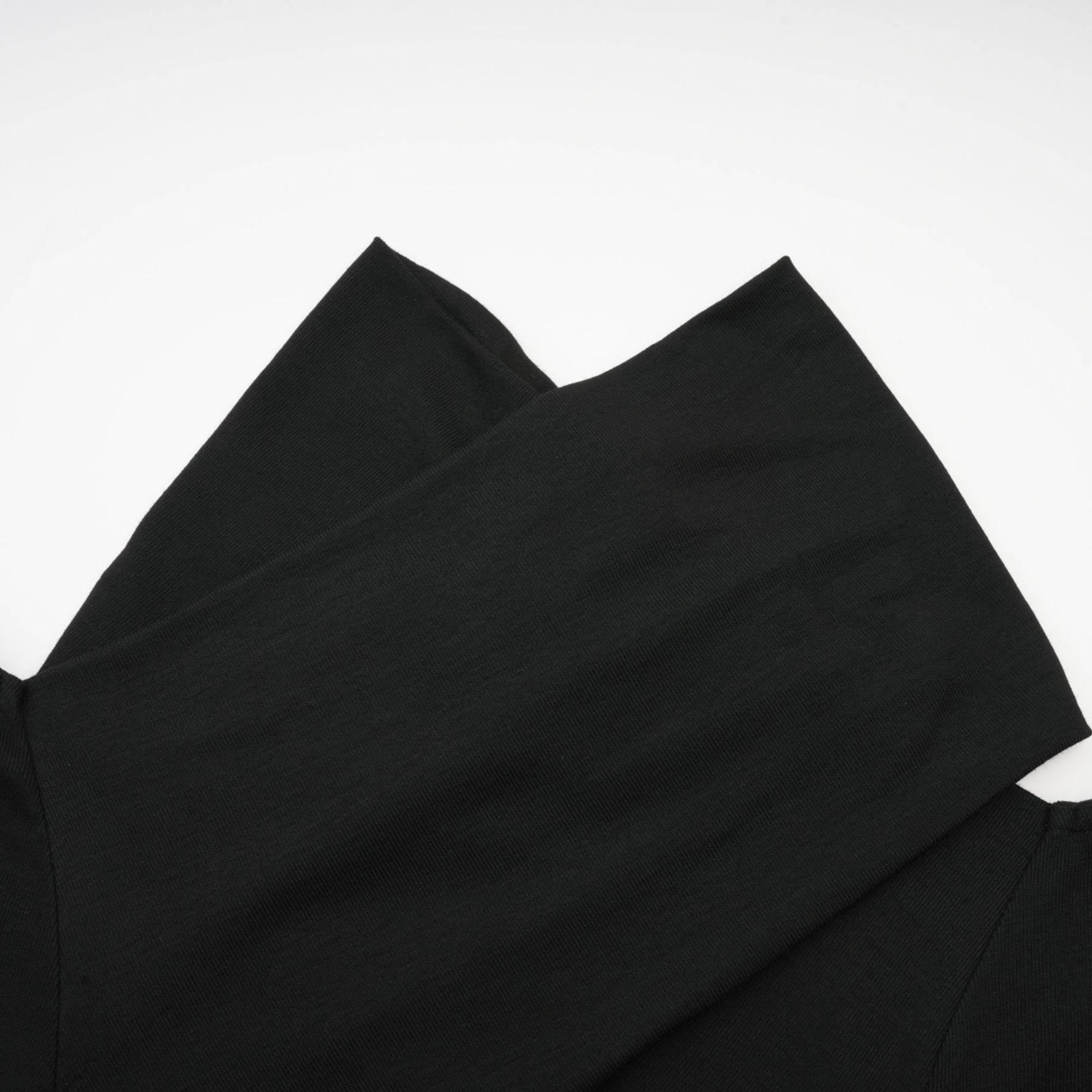 A black ruched top with long sleeves made of stretchy jersey fabric named Odette