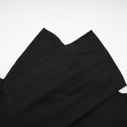 A black ruched top with long sleeves made of stretchy jersey fabric named Odette