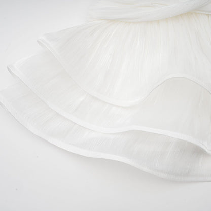 A white mini dress with full pleats and a cinched waist featuring a formfitting silhouette and short length