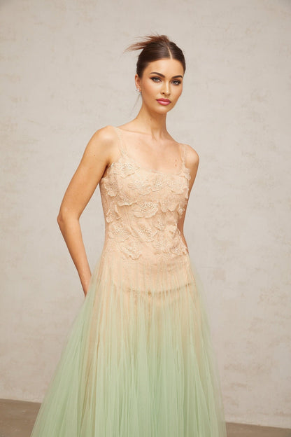 Woman wearing a green midi dress with lace panels and tulle skirt