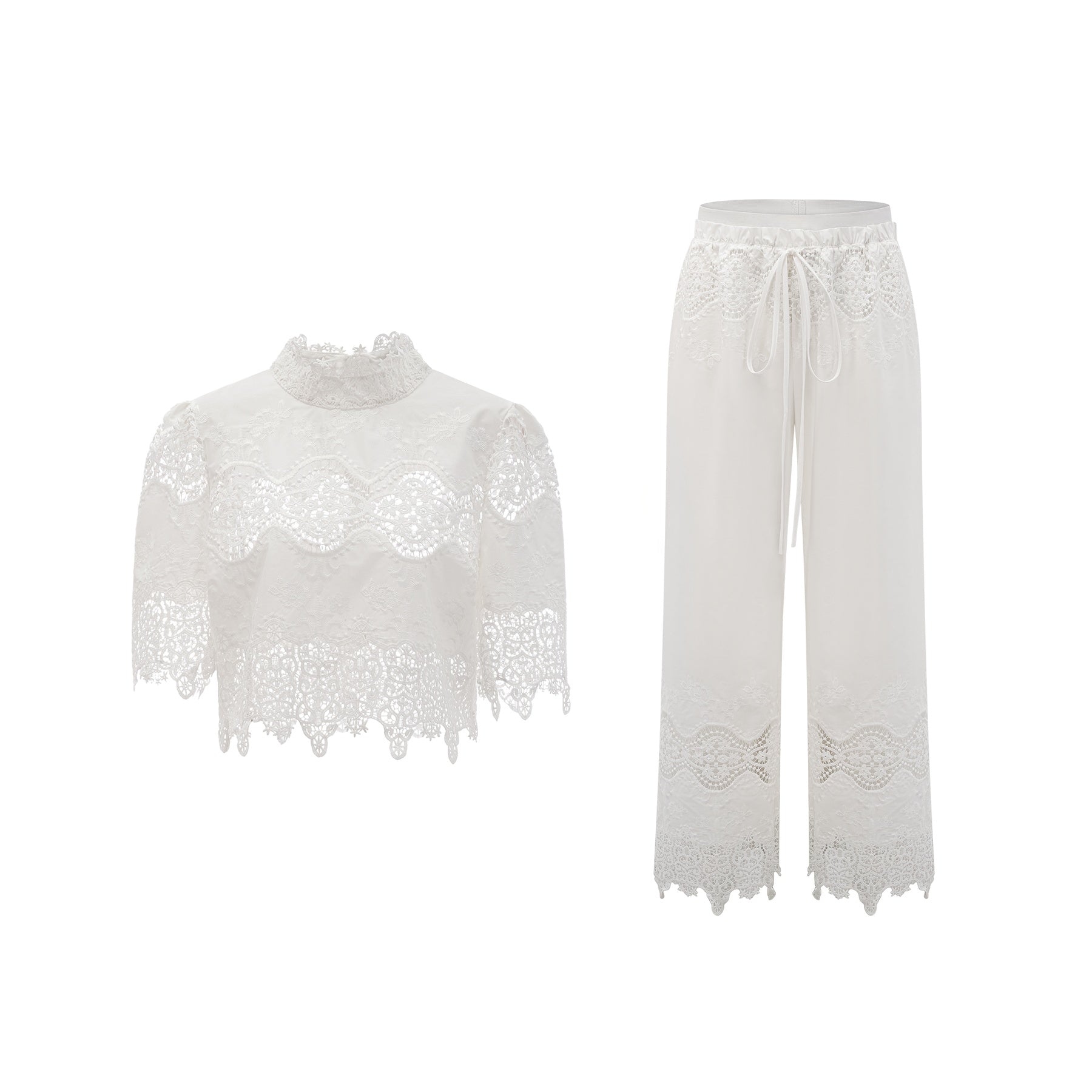 Woman wearing white lace trim cropped top and matching trousers set featuring cutout details