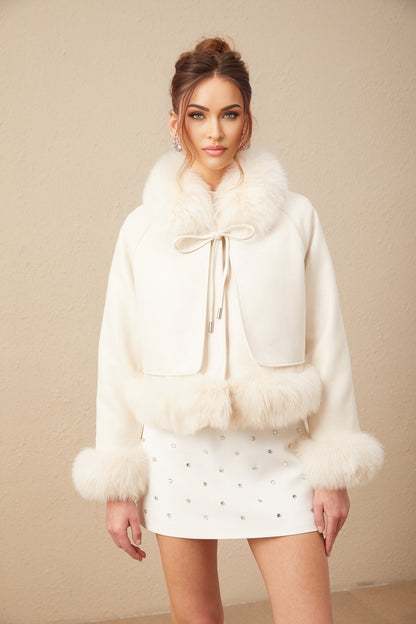Woman wearing white suede short coat with fur trim and padded design