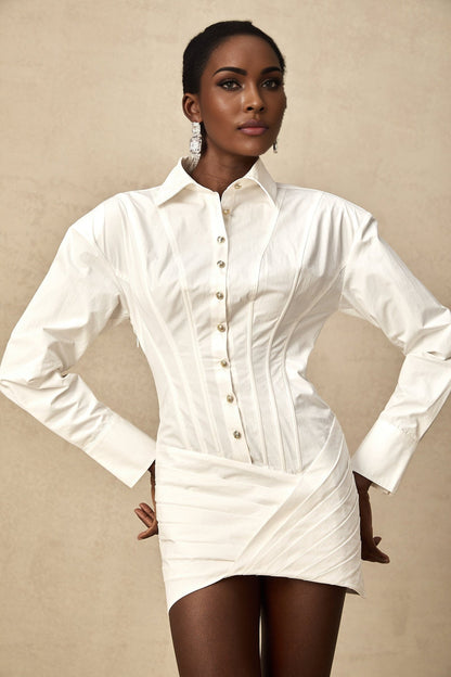 A white pleated mini shirt dress with a fitted waist
