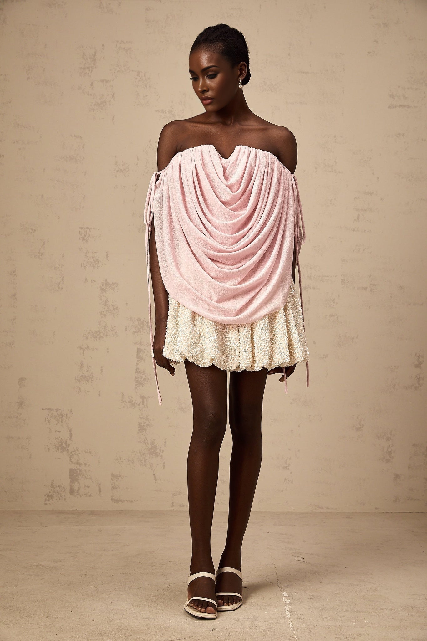 A woman wearing a pink offshoulder top with ruched detailing