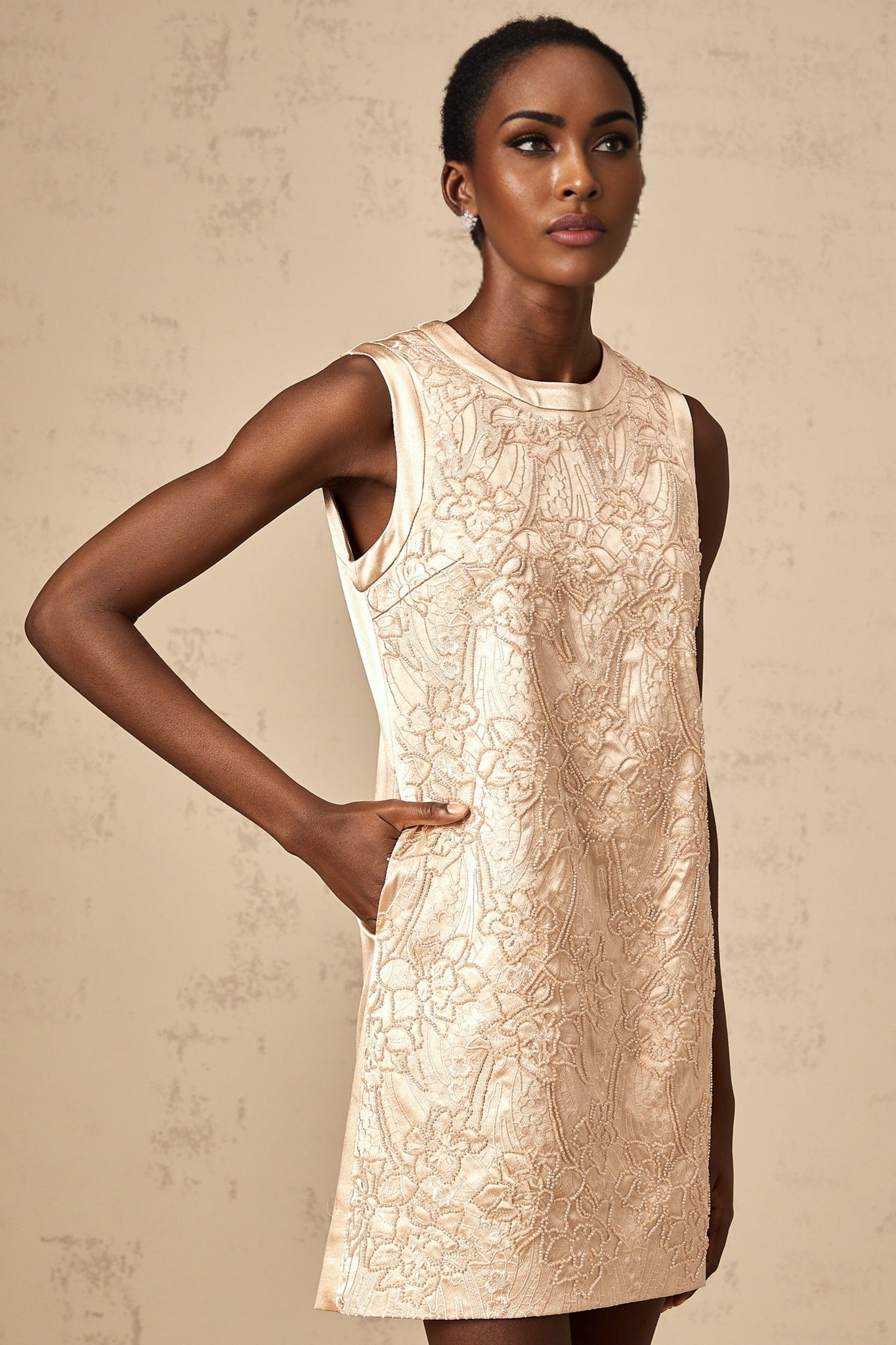 A short white mini dress with intricate embroidery and beaded embellishments adorning the fabric