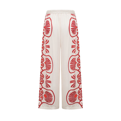 Woman wearing matching floral print shirt and trousers set in vibrant colors with Amaranta design