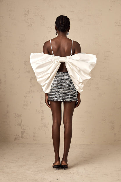 A white sleeveless top with a scoop back and decorative bowknot detail named Solene