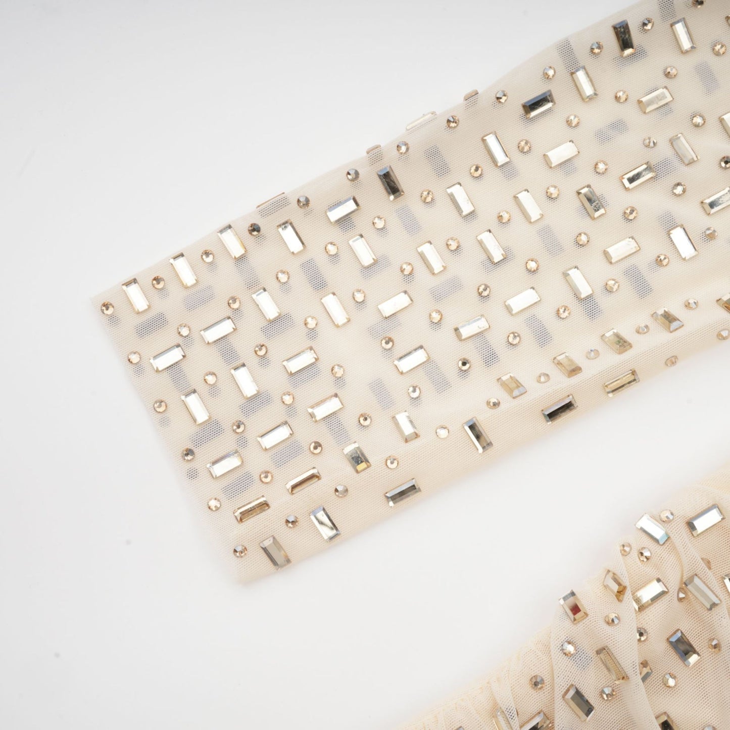 A short sleeveless mini dress with crystal embellishments and draped fabric detail