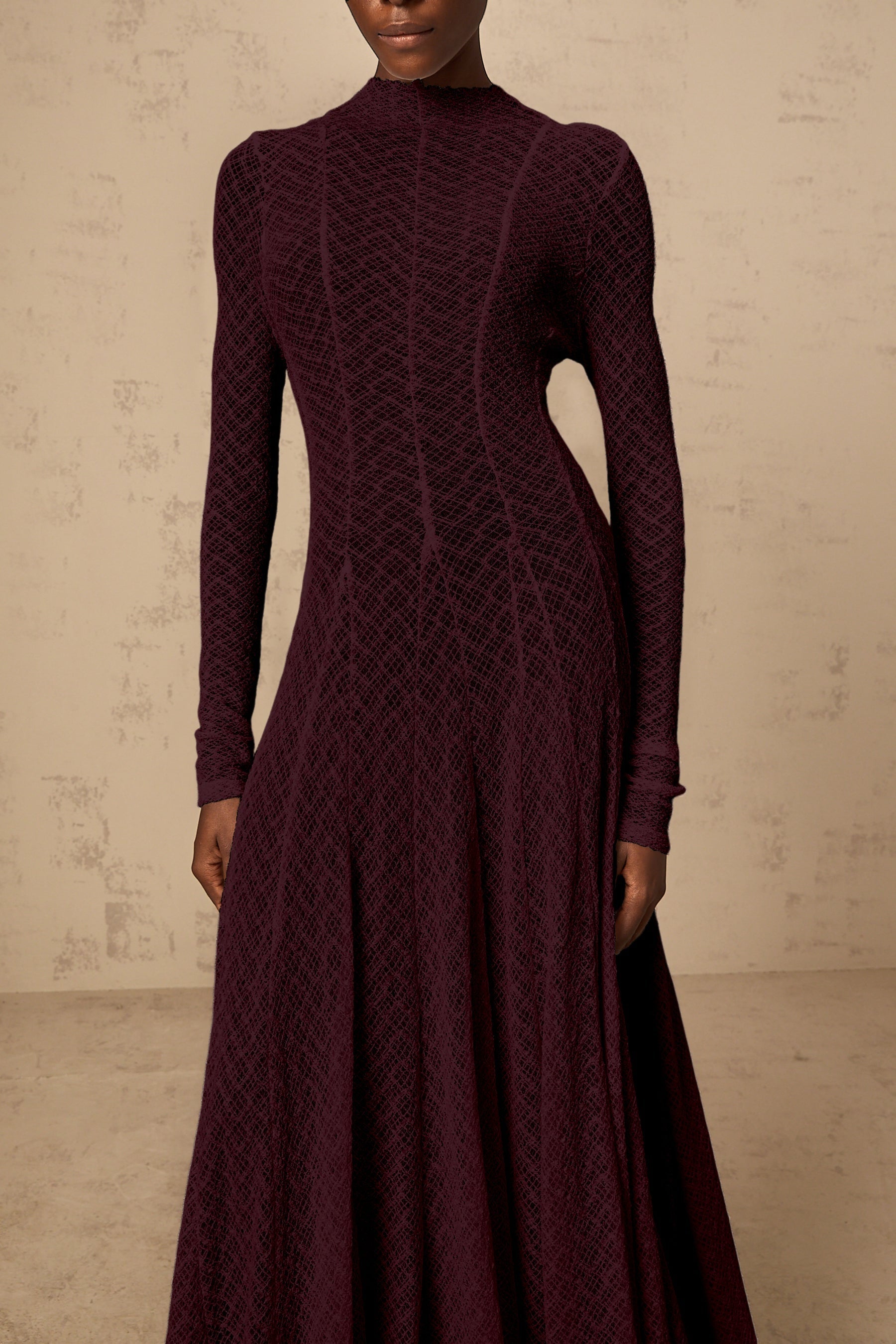 A long red maxi dress with a wavy lace pattern covering the entire garment The dress features a feminine silhouette and delicate detailing