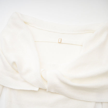 Woman wearing a white knitted strapless long sleeve top with textured pattern
