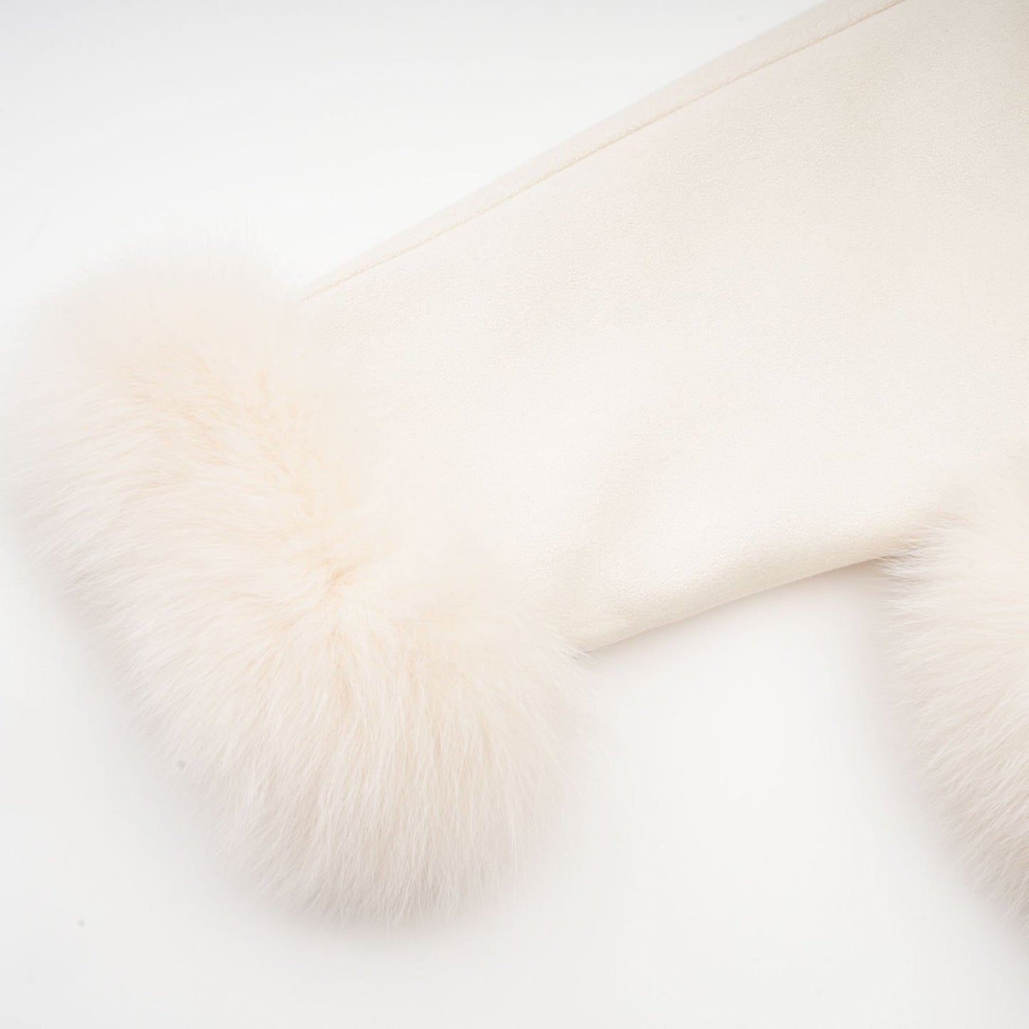 Woman wearing short white suede coat with fur trim and padded design