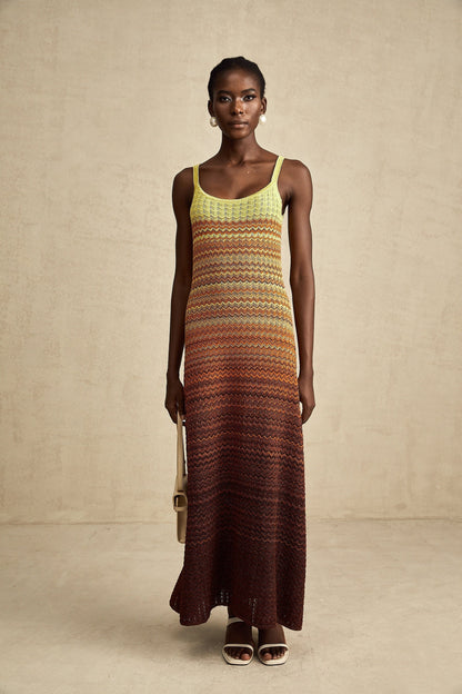 Woman wearing long knitted maxi dress with gradient colors in shades of blue