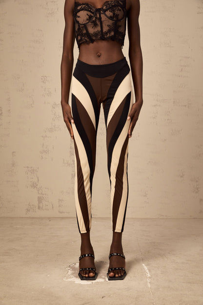 Woman wearing colorful spiral patterned leggings with color block panels in various shades