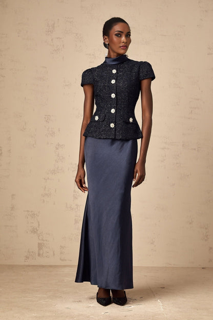 Woman wearing a long blue maxi dress with peplum waist and panelled design