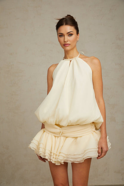 A white halterneck mini dress with faux pearl embellishments named Berenice