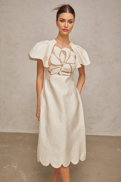 A white midi dress with floral jacquard pattern featuring a fitted bodice and flared skirt
