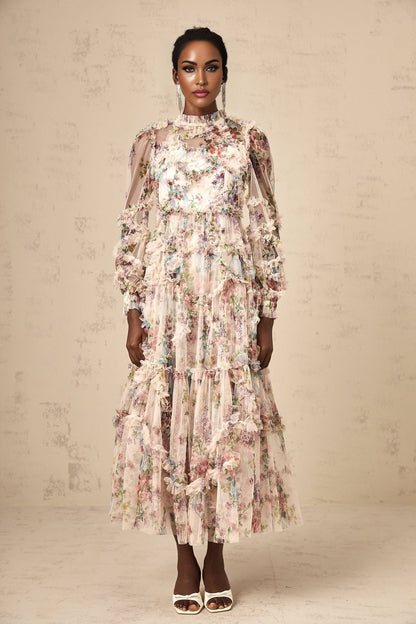 A woman wearing a floral patterned midi dress with ruffled details and a tulle skirt