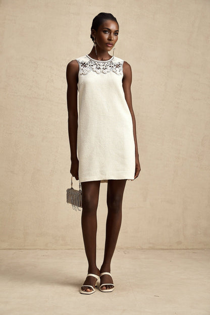 A short tweed mini dress with embroidery details and cut out sections featuring a feminine silhouette in a classic style