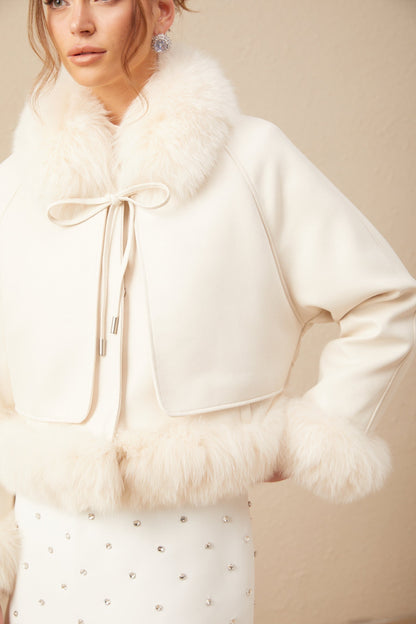 Woman wearing white short suede coat with fur trim and padded design
