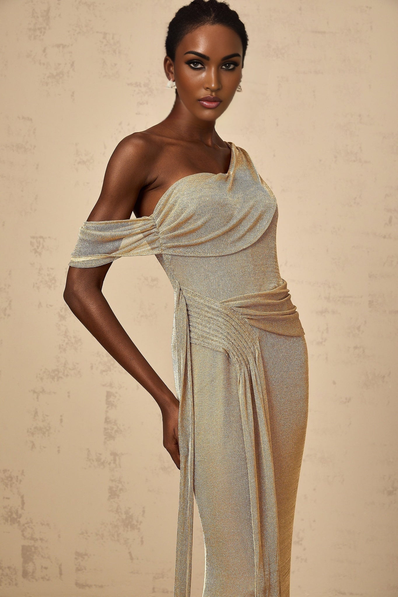 A long gold maxi dress with a gathered waist and ribbon design details