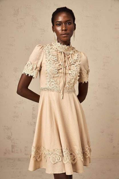 A woman wearing a short flared mini dress with corded lace detailing and a feminine silhouette