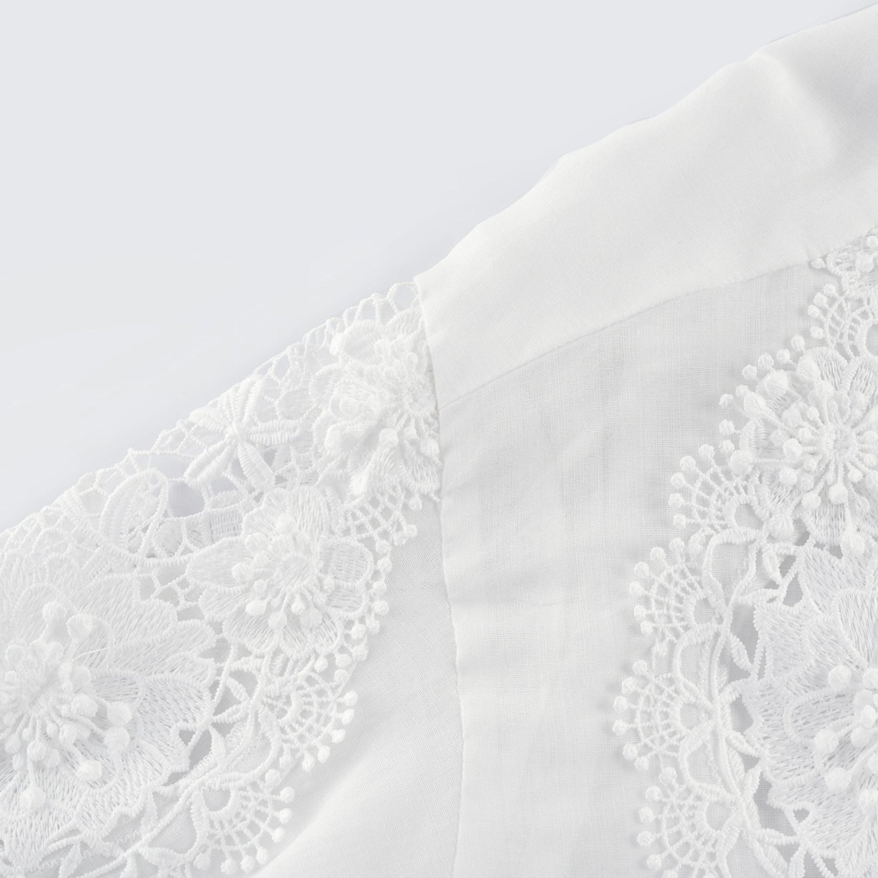 White long sleeve shirt with lace embroidery detailing and cut out design on shoulders