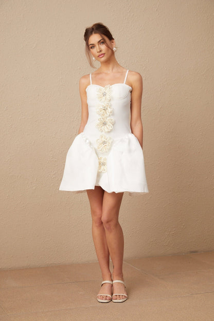 A white mini dress with a bustier top featuring a floral pattern The dress has a fitted bodice and a short skirt