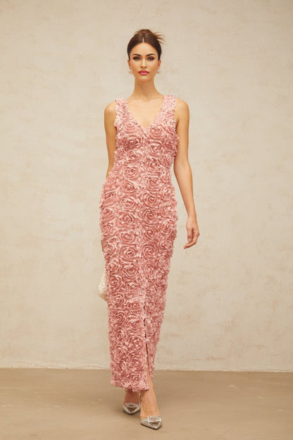 Woman wearing long pink floral maxi dress with Vneck and faux flower pattern