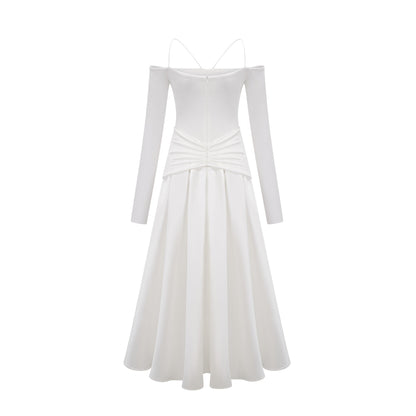 White offshoulder maxi dress with panels worn by model standing against plain background