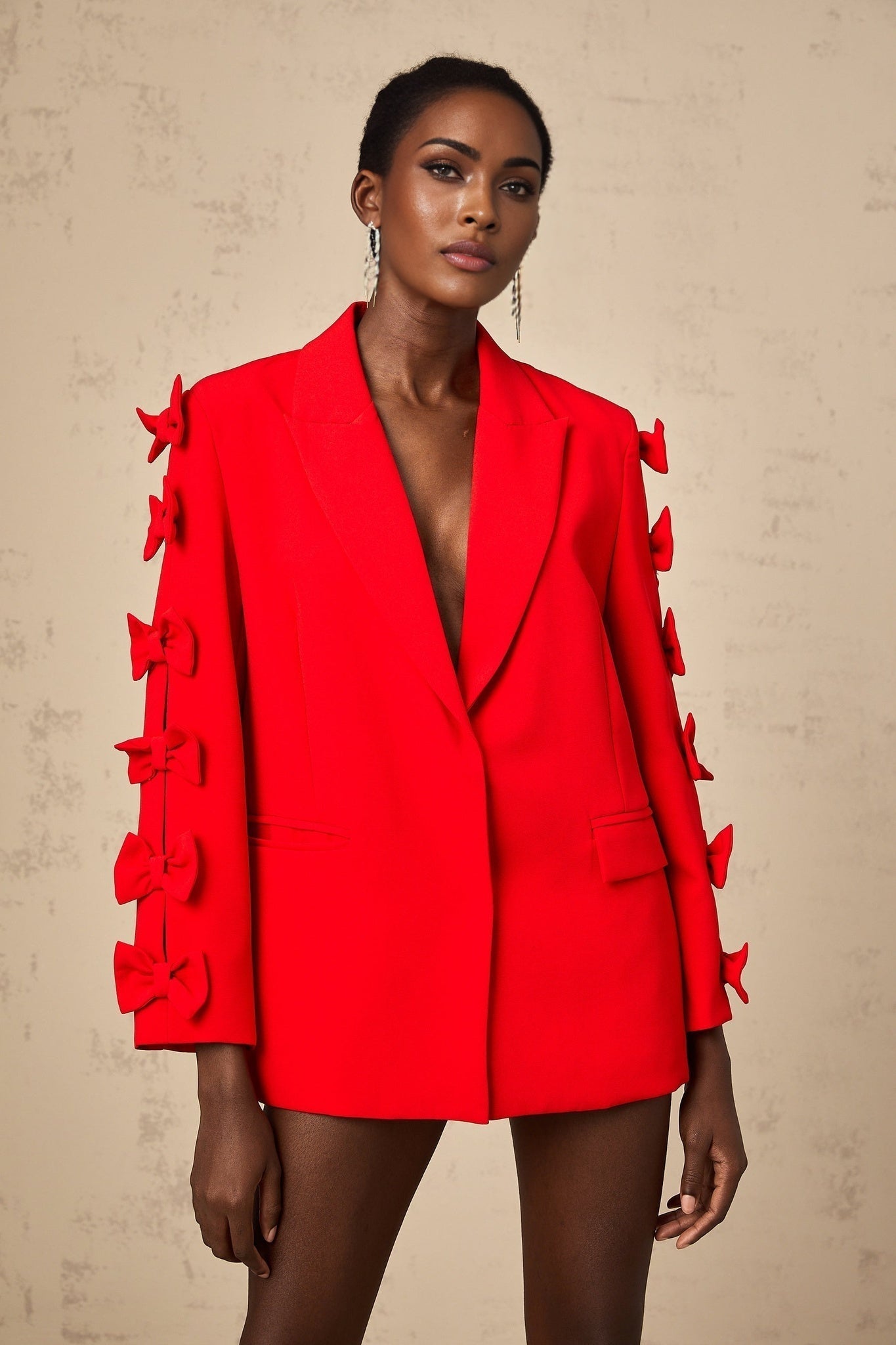 A red blazer with a bowknot detail and cutout design featuring a feminine silhouette and bold color