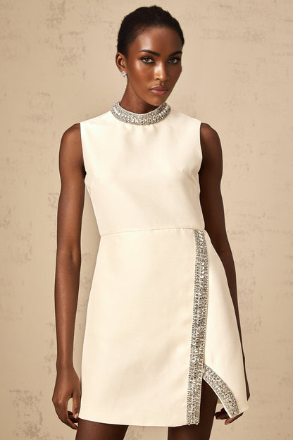 A short white mini dress adorned with crystal embellishments featuring a fitted silhouette and Babette style design