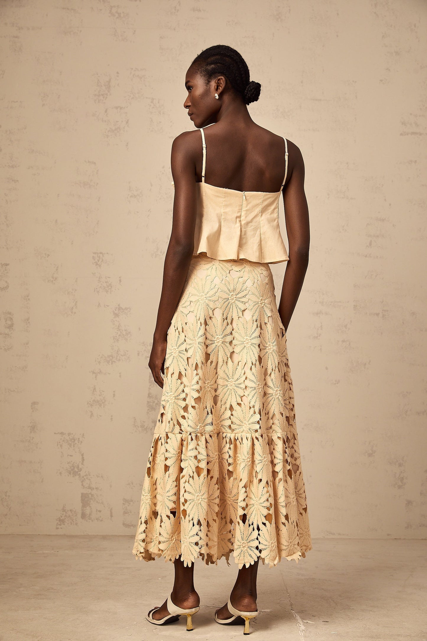 A khaki colored matching set featuring a flared top with cut out details and a coordinating skirt by Celine