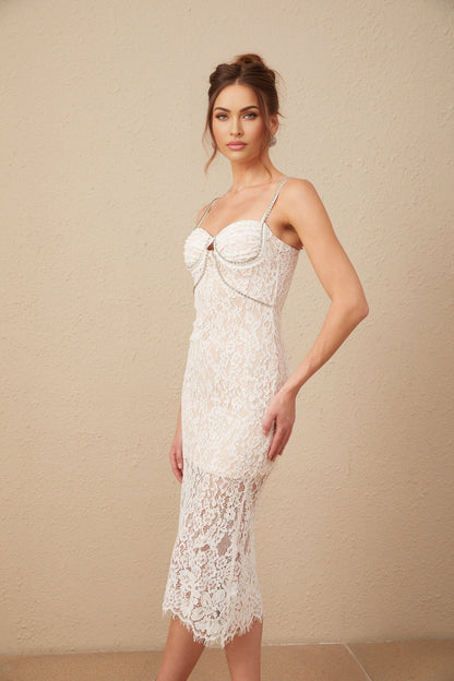 Woman wearing white lace midi dress with crystal embellished bustier top form fitting silhouette and delicate floral lace pattern