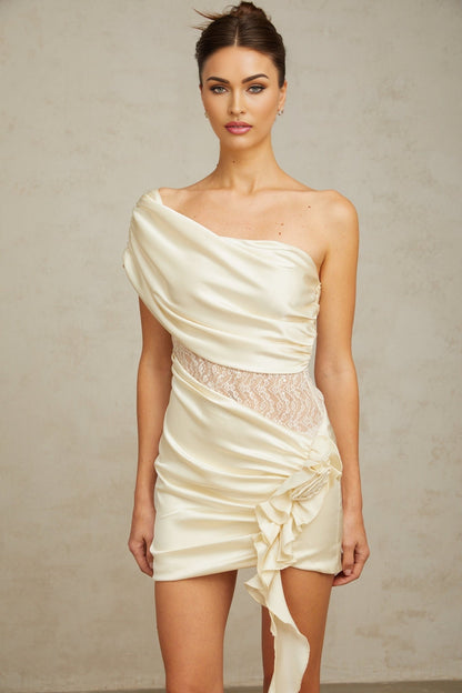 A beige asymmetric mini dress with lace panel details and a neutral color scheme