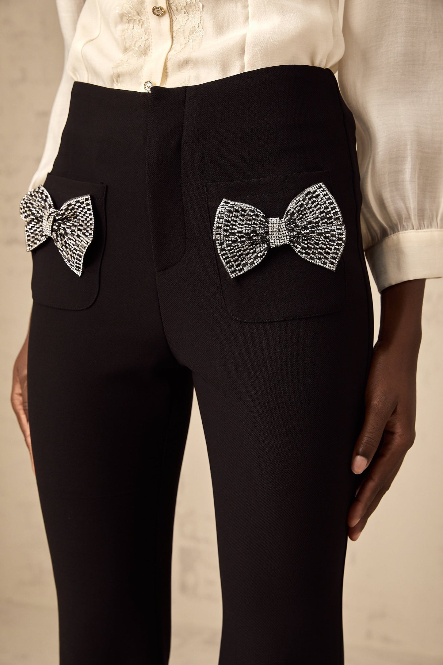 Pair of flared trousers with a bow embellishment on the waistline