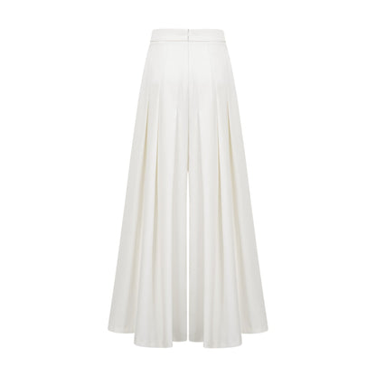 A white matching set featuring a creased top and trousers worn by a model standing against a plain background
