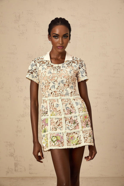 A short white mini dress with colorful floral embroidery featuring a fitted bodice and flared skirt