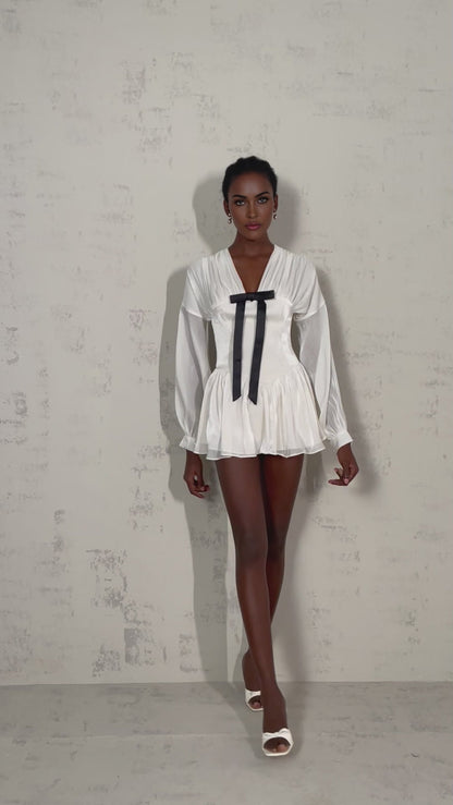 A short white mini dress with a bowknot detail and glitter accents named Lina