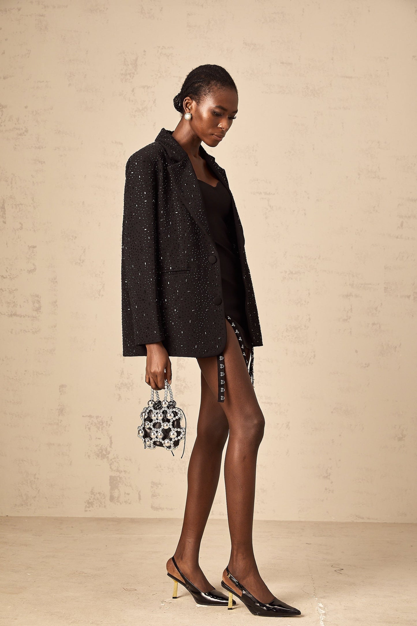 A black blazer with decorative studs adorning the fabric featuring a tailored silhouette and long sleeves
